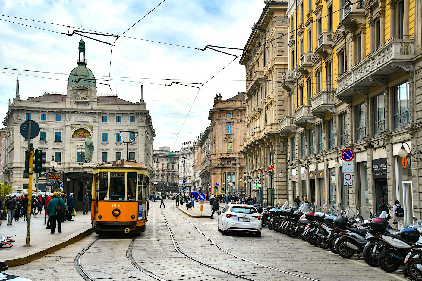 Milan trolley passes through the neoclassical architecture of Piazza Cordusio